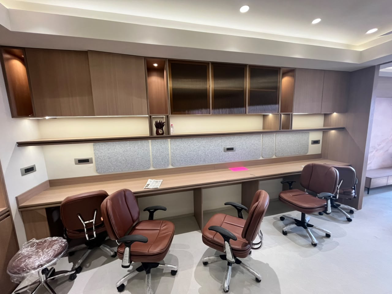 Long shared workstation with ribbed glass overhead units